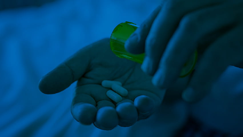 person dispensing prescription opioid into their hand 